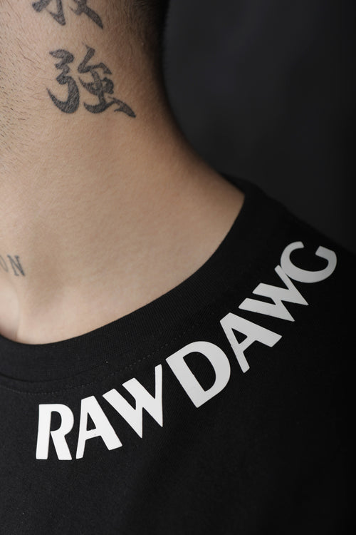 Person wearing a black t-shirt with 'RAWDAWC' printed on it, showing tattoos on neck and shoulder.