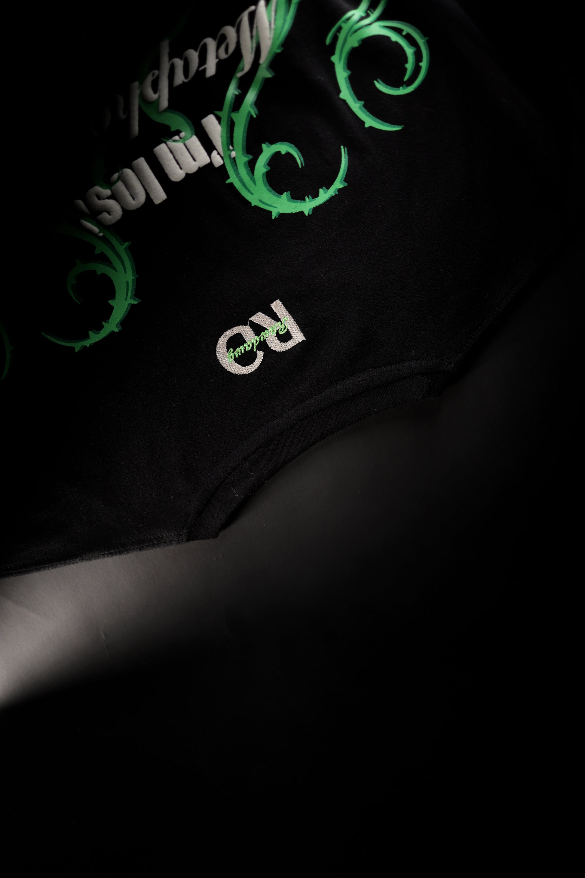 Black regular t-shirt with green and white text on a dark background